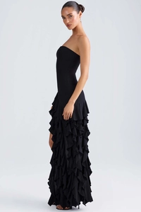 Détail de la robe de soirée noire bustier avec ourlet à volants superposés et coupe slim