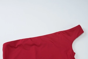 Gros plan sur la robe rouge à une épaule montrant les coutures et le tissu extensible