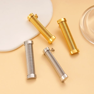 Macro shot of gold and silver vertical spring earrings with industrial minimalist texture