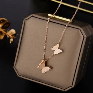 Rose gold titanium steel necklace featuring double butterfly pendants on jewelry box