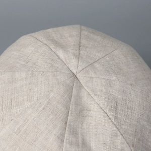Vue macro du haut du chapeau en lin montrant les coutures de qualité et la texture du tissu