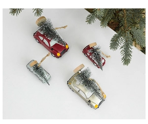 Detailed view of four festive miniature car ornaments with tiny trees and jute loops