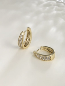 Detail of gold U-shaped hoop earrings with micro-pave white cubic zirconia stones