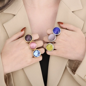 Set of luxury chunky stainless steel rings with colorful round gemstones on female hands