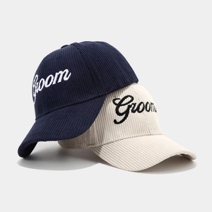 Detail of Groom embroidery on corduroy baseball caps in navy blue and cream white