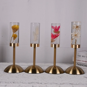 Detail of preserved flower acrylic lamps with golden bases on a white lace tablecloth