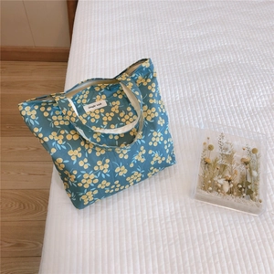 Detailed view of blue cotton handbag with yellow cherry pattern and zipper closure