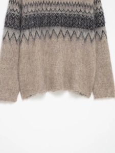 Close-up of geometric jacquard knit sweater with soft brushed mohair texture and hem detail