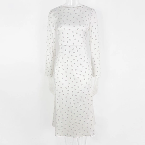 Detail of white long sleeve floral dress showing smooth satin sheen and red flower prints