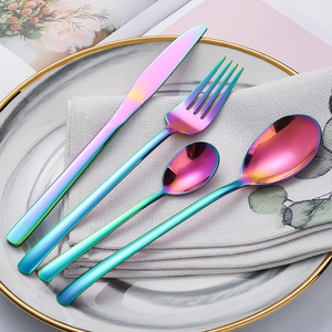 Set posate 4 pezzi in acciaio inox arcobaleno con coltello e forchetta su piatto marmo