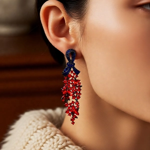 Gros plan de boucles d'oreilles vintage avec nœud et longs pompons rouges