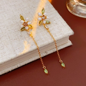 Elegantes pendientes de flor blanca con circonitas verdes y cadena larga bañada en oro