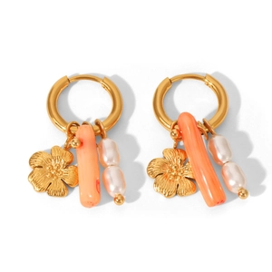 Golden flower earrings with orange pendants and white pearl strands on a plain background