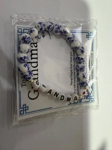 Dettaglio del braccialetto GRANDMA con perline in ceramica blu e bianca e confezione regalo