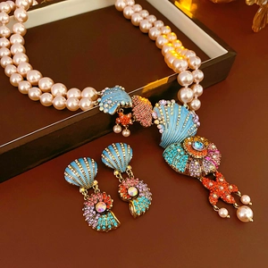 Detail of vintage necklace set with pearl, enamel starfish and conch in a jewelry box