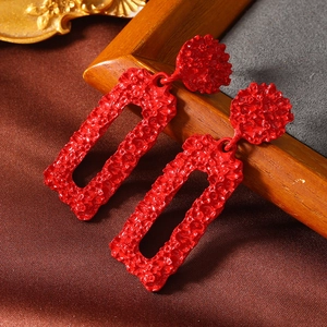 Retro red textured metal geometric hollow rectangle earrings on vintage silk background