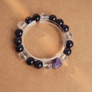 Détail d'une perle améthyste rectangulaire et perles de cristal polies sur le bracelet élastique