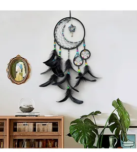 Detail of bohemian black dream catcher featuring moon star beads and soft feathers