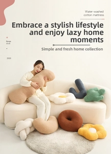 Detailed view of assorted creative floral and knot plush pillows on a cozy sofa
