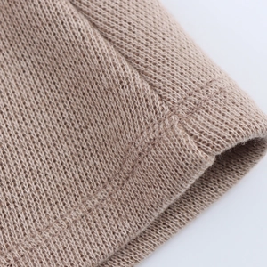 Detailed close-up showing texture of brown soft knit fabric and fine stitching on the garment