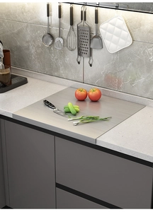 Polished stainless steel cutting board with folded edge on a kitchen countertop