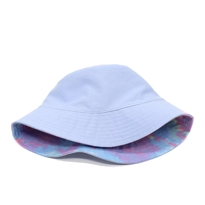 Detail of reversible bucket hat showing light purple solid side and colorful tie-dye pattern