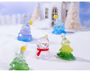 Detailed close-up of mini glass Christmas tree and snowman figurines for DIY micro landscapes