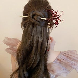 Detailed view of red Lycoris flower hair pin with golden tassels on elegant hairstyle