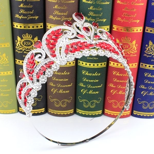 Detail of silver bridal crown with red and clear zircons against a book background