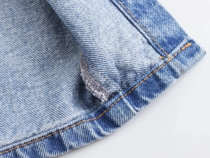 Dettaglio della texture del denim blu lavato e della qualità delle cuciture professionali