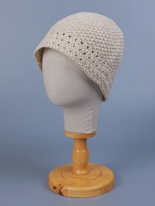 Detail of beige crochet bucket hat with hollow pattern on a professional model head