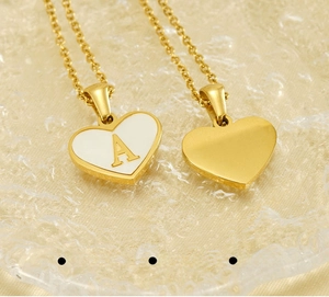 Detailed close-up of heart-shaped shell pendant showing gold-plated letter A and smooth back