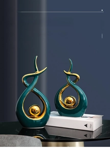 Detail of luxury green ceramic sculpture set with gold ball and elegant reflections