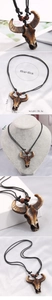 Detail of tribal bull head pendant necklace with wood beads and engraved patterns
