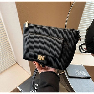 Detailed view of black vertical pleated leather bag with gold metal clasp and chain