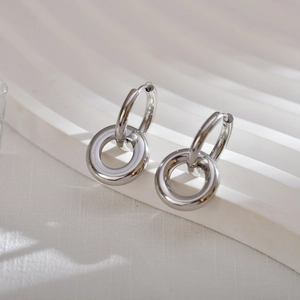 Macro detail of minimalist silver dual-ring earrings in polished stainless steel