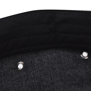 Detail of black cotton denim fabric with reinforced silver eyelets and neat stitching
