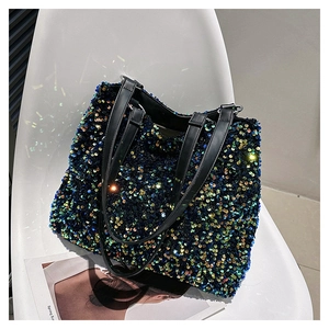 Detail of multi-color sequins on a tote bag with black faux leather handles on a white chair