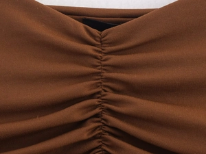 Detailed close-up of brown ribbed knit fabric with professional ruched stitching detail