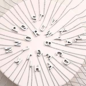 Macro shot of silver stainless steel alphabet pendants arranged on a white display