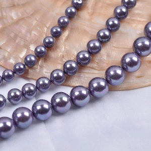 Macro shot of deep purple glass pearls on silk fabric with sea shell texture