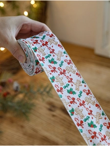 Close-up of white Christmas ribbon featuring gingerbread man and candy cane prints