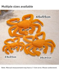 Three sizes of orange plush king crab toys laid on a soft carpet background