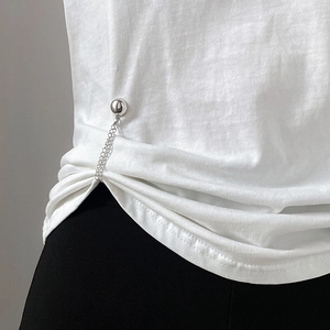 Detail of silver metal ball chain magnetic buckle fixing the white T-shirt hem