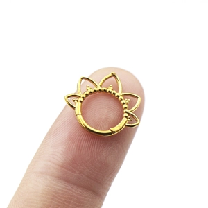 Détail d'un anneau de septum en acier 316 doré en forme de fleur de lotus