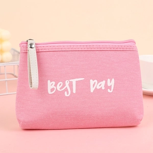 Pink canvas makeup bag with BEST DAY lettering and stylish white handle in lifestyle setting
