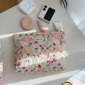 Detailed top view of quilted floral makeup bag with metal zipper and soft cotton texture