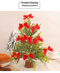 Close-up of decorative red velvet bows on mini Christmas tree branches for holiday decor