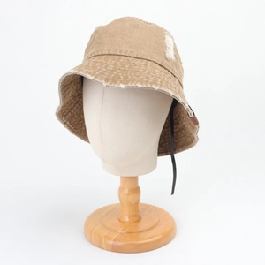 Détail du bord effiloché sur un chapeau bob en denim délavé au style vintage pour femme