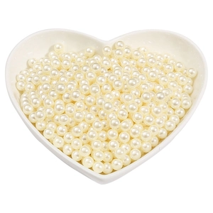 Off-white round ABS pearls displayed in a heart-shaped tray for DIY jewelry making